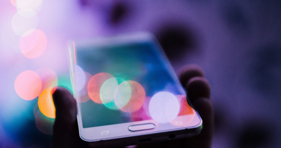Image of a hand holding a smartphone accessing the digital world