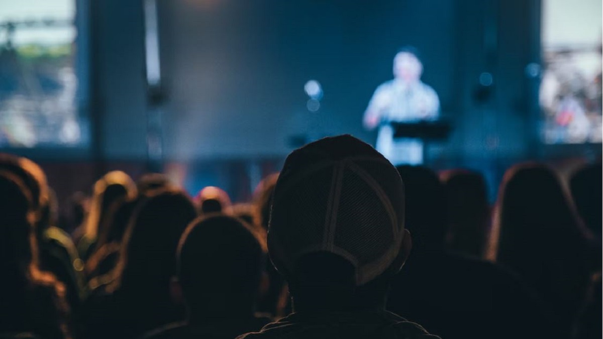 Image of back of a person's head watching a live conference