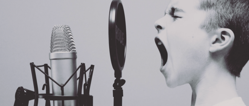 Child screeming into a microphone to amplify their voice